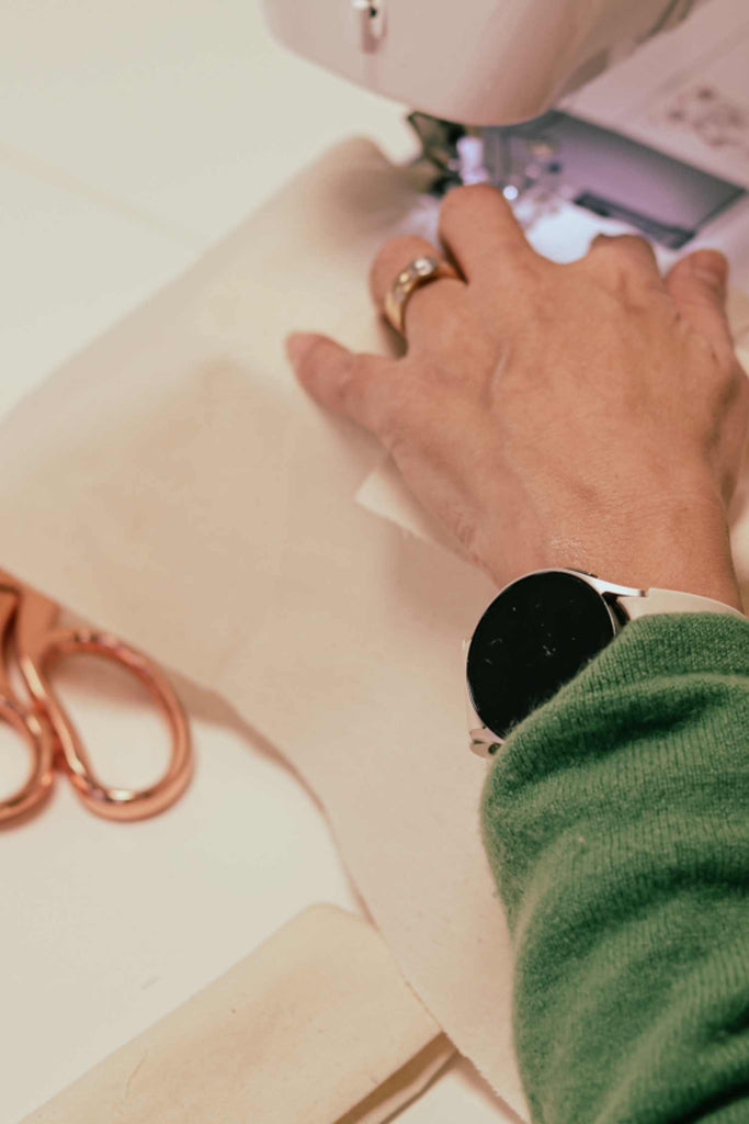 Leim Sewing workshops - jumpsuit sewing workshops - Person using a sewing machine with a close-up of hands and a watch.